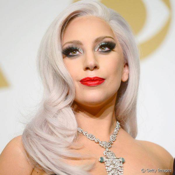 Lady Gaga combinou make de olhos ultra intensa e brilhosa com batom vermelho vivo